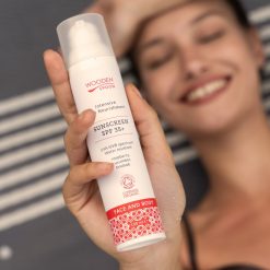 Wooden Spoon Organic Sunscreen SPF 35 i airless pumpflaska – ekologiskt, vattenresistent mineral­solskydd för ansikte och kropp. Hålls i handen av kvinna